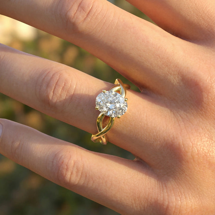 Oval diamond engagement ring with sculpted twisted band design.