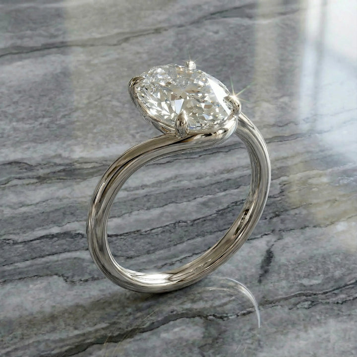 Oval lab-grown diamond solitaire engagement ring shown in cathedral setting on reflective surface.
