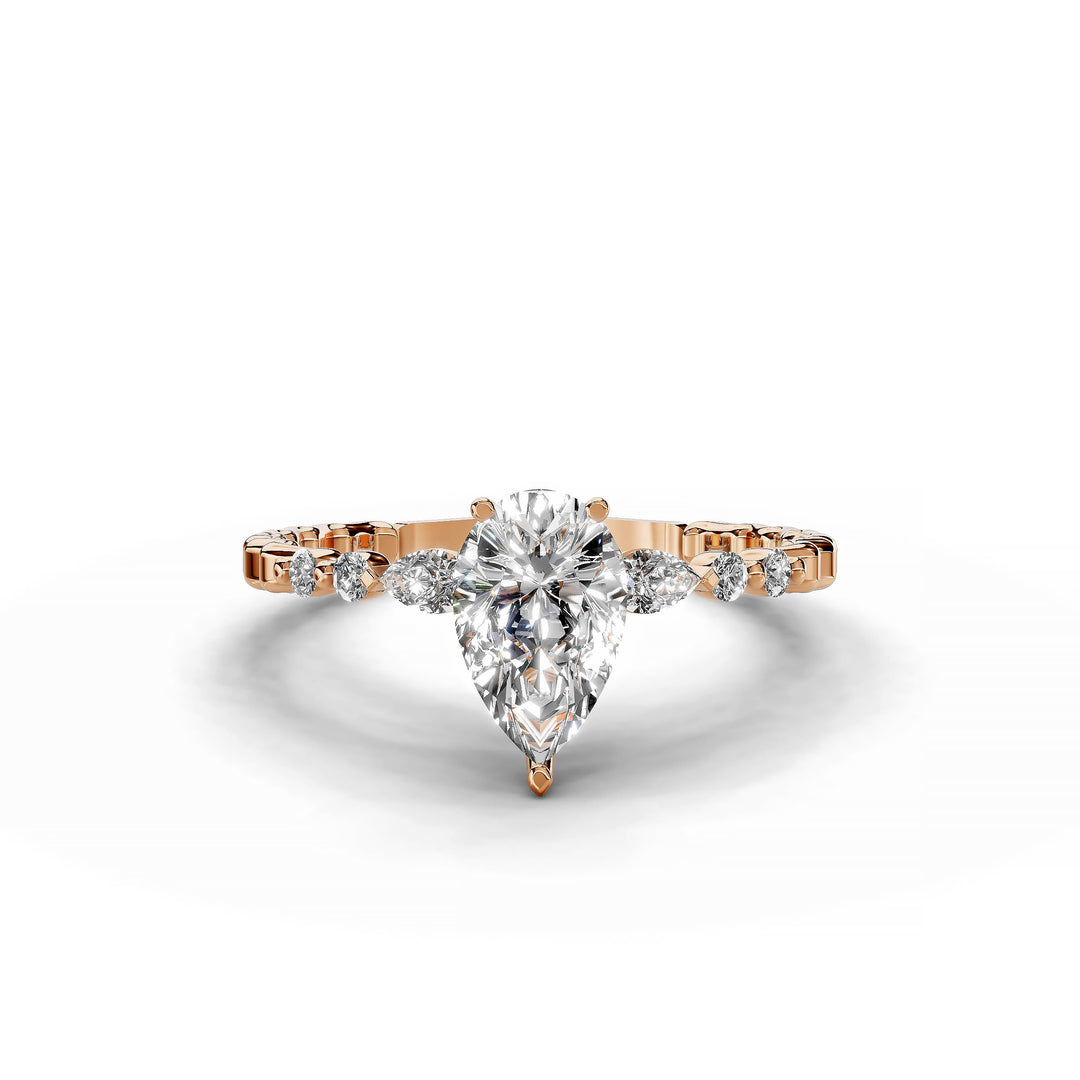 Pear-shaped diamond three-stone engagement ring with geometric segment band shown in display view.