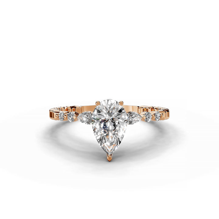 Pear-shaped diamond three-stone engagement ring with geometric segment band shown in display view.