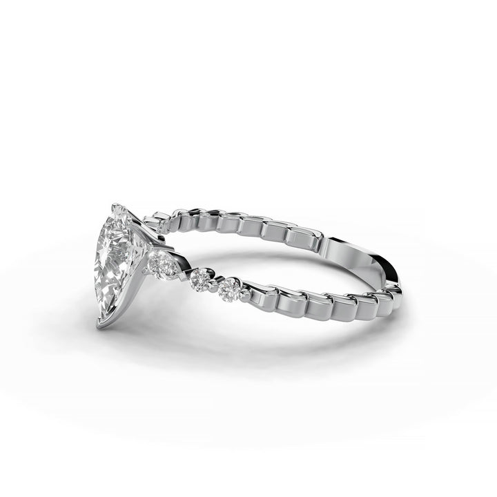 Pear-shaped diamond three-stone engagement ring with geometric segment band shown in display view.