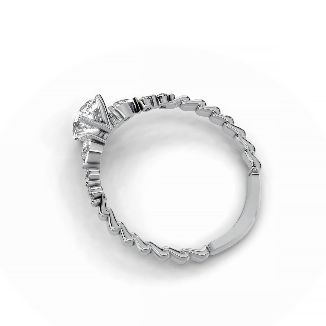 Pear-shaped diamond three-stone engagement ring with geometric segment band shown in display view.