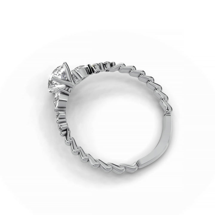 Pear-shaped diamond three-stone engagement ring with geometric segment band shown in display view.