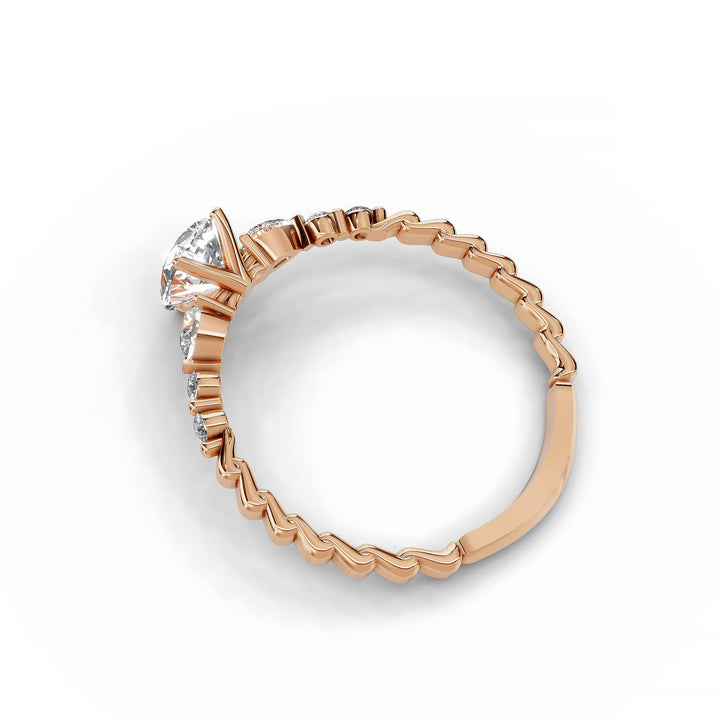 Pear-shaped diamond three-stone engagement ring with geometric segment band shown in display view.