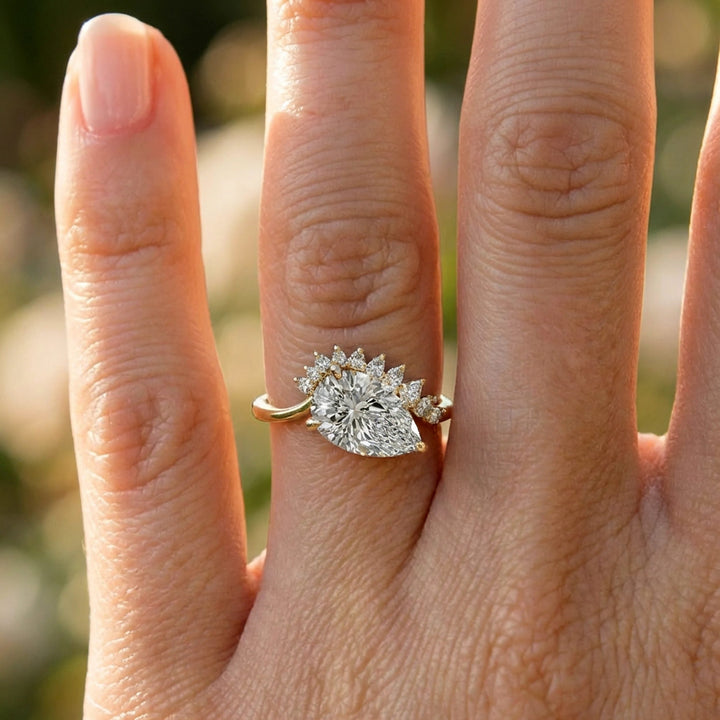 2.5 carat pear lab-grown diamond engagement ring with pear accents displayed on marble surface.