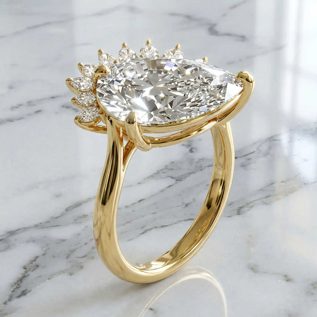 2.5 carat pear lab-grown diamond engagement ring with pear accents displayed on marble surface.
