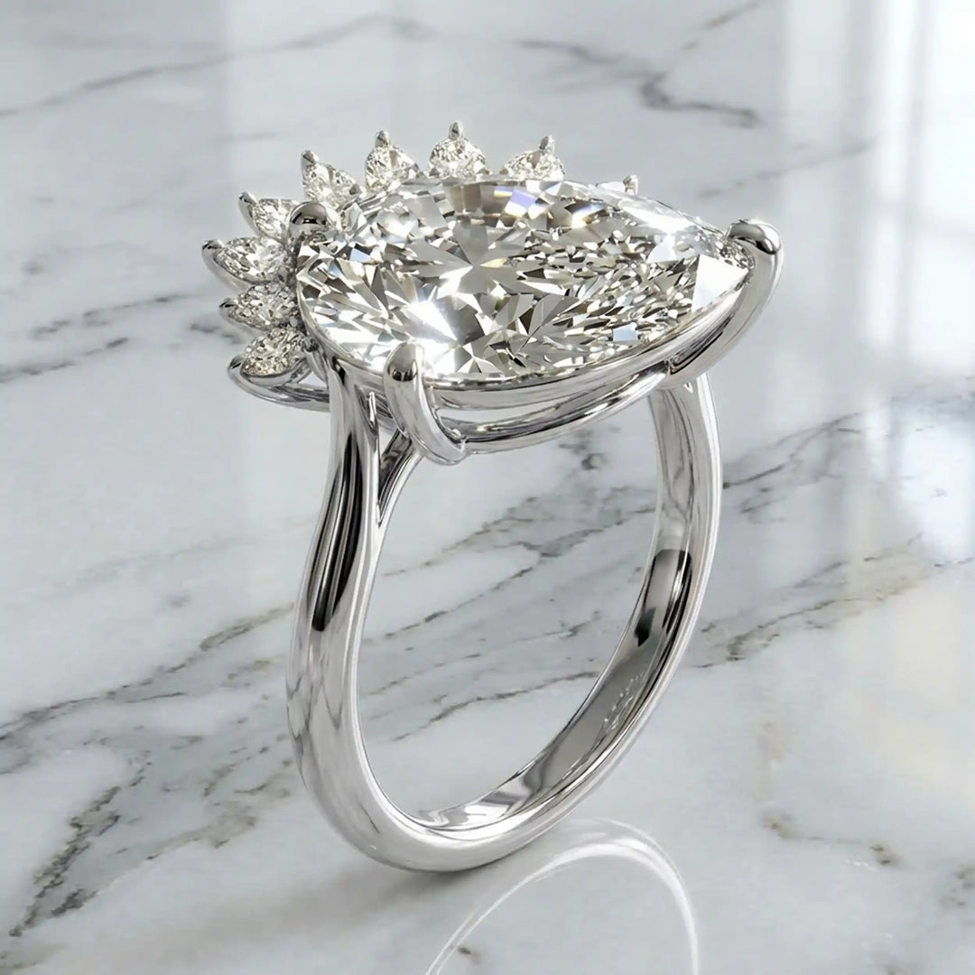 2.5 carat pear lab-grown diamond engagement ring with pear accents displayed on marble surface.
