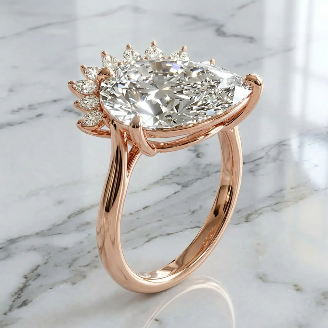 2.5 carat pear lab-grown diamond engagement ring with pear accents displayed on marble surface.
