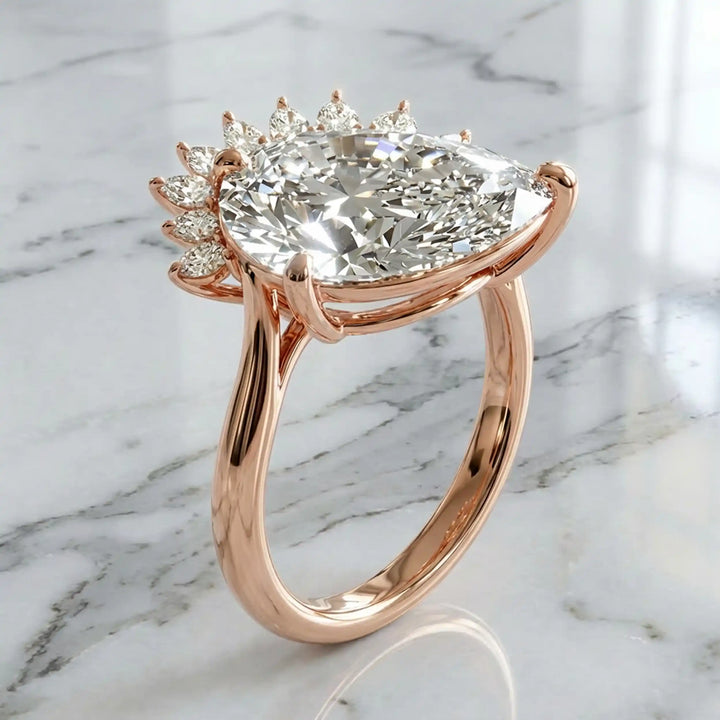 2.5 carat pear lab-grown diamond engagement ring with pear accents displayed on marble surface.
