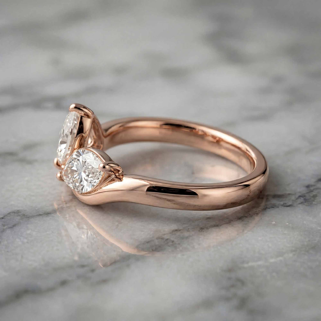 1.10 carat pear and marquise lab-grown diamond toi et moi engagement ring displayed on marble.
