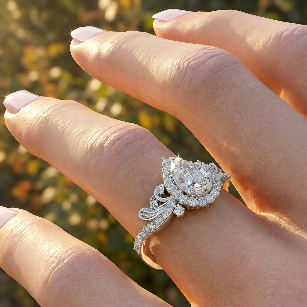 Vintage pear-shaped diamond engagement ring with ornate halo and sculpted detailing.