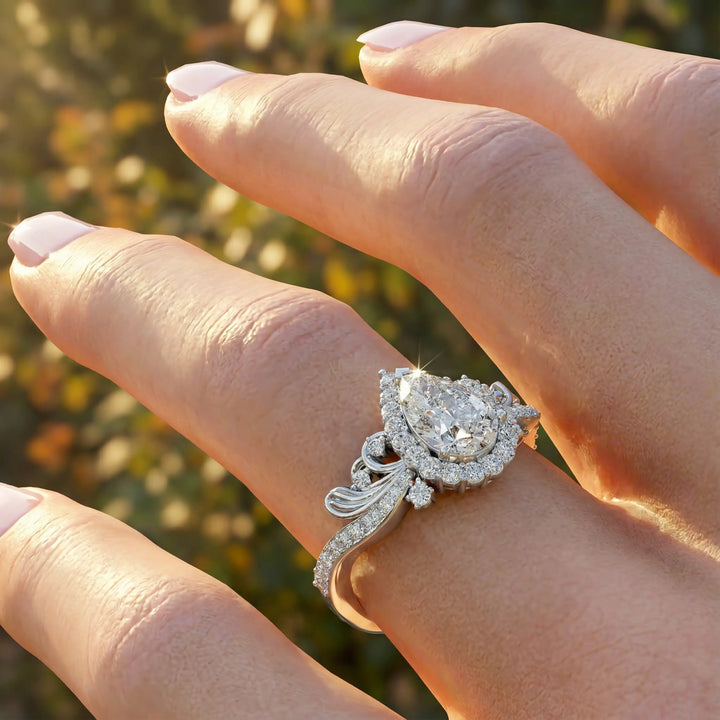 Vintage pear-shaped diamond engagement ring with ornate halo and sculpted detailing.