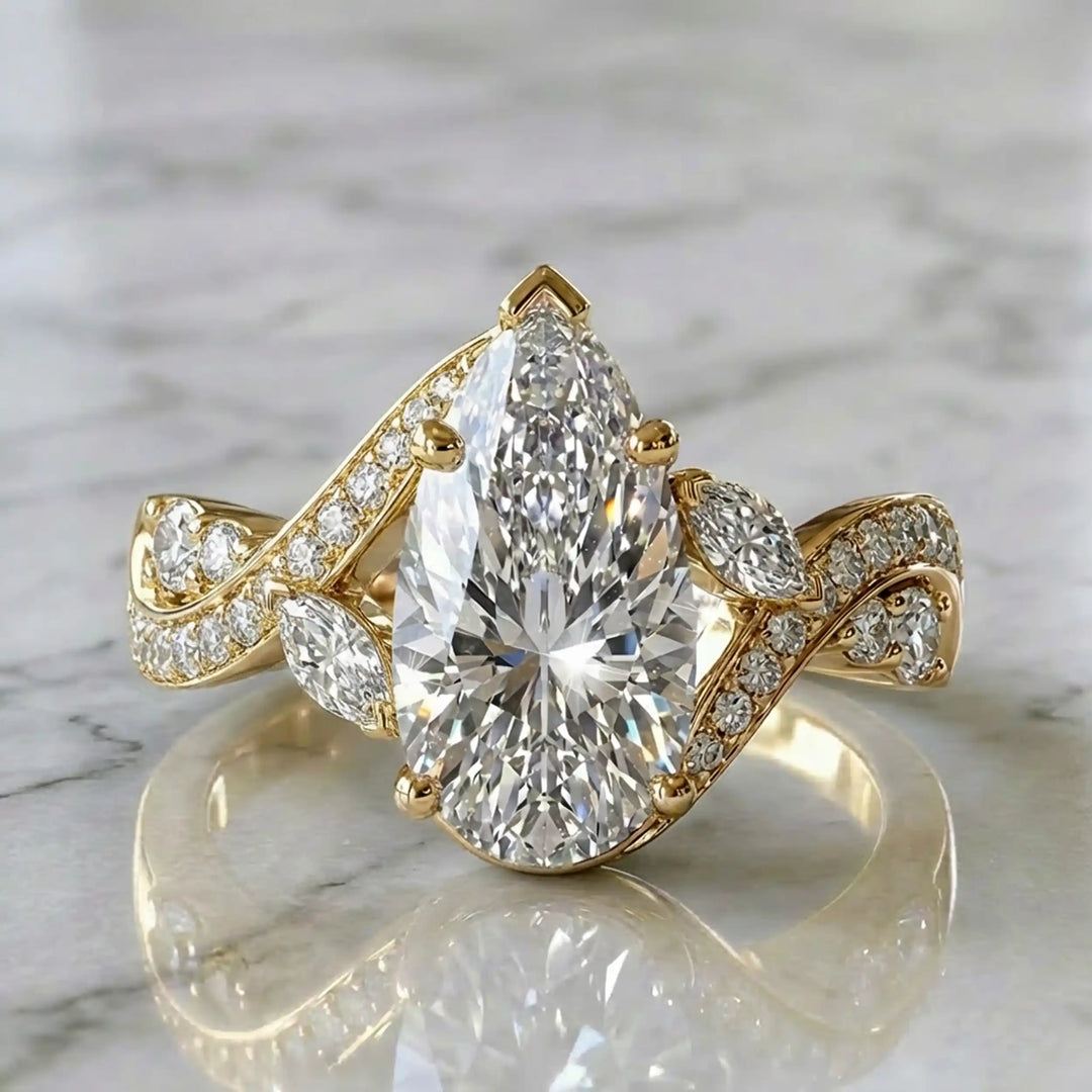 3 carat pear lab diamond twisted three-stone engagement ring displayed on marble surface.
