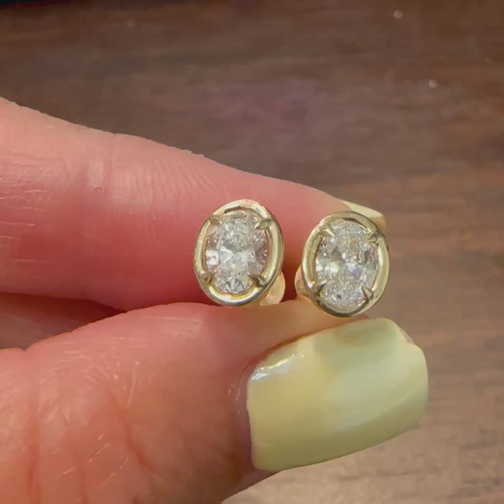 Certified oval-shaped lab grown diamond stud earrings in yellow gold bezel setting