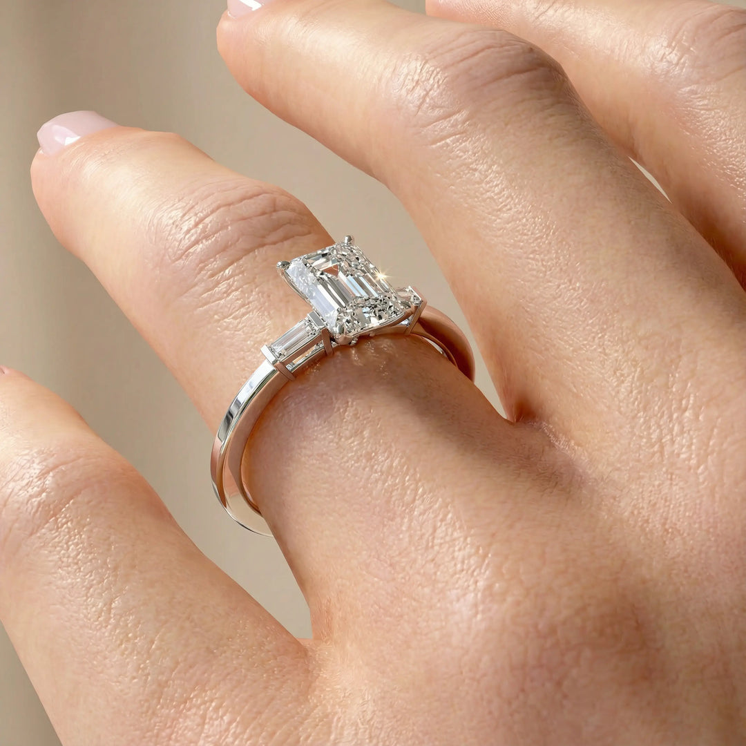 Radiant cut three stone engagement ring with tapered side diamonds.