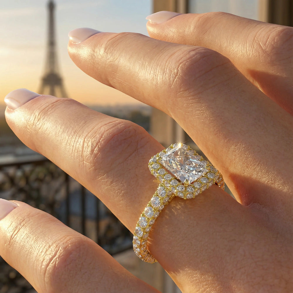Radiant-cut diamond halo engagement ring with triple prong-set diamond band shown in display view.