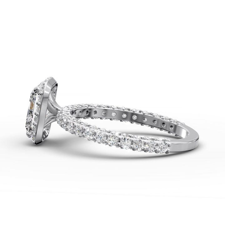 Radiant-cut diamond halo engagement ring with triple prong-set diamond band shown in display view.