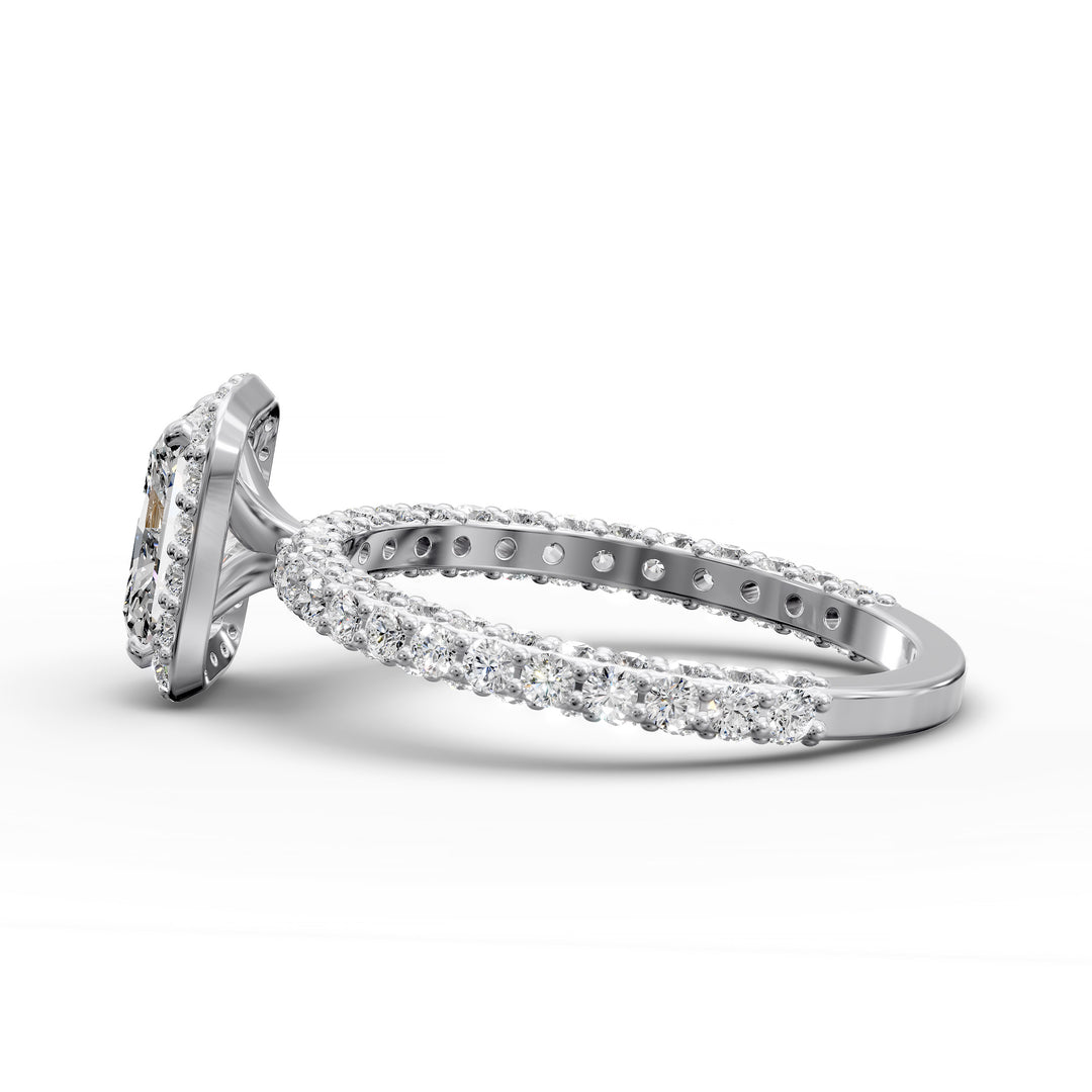 Radiant-cut diamond halo engagement ring with triple prong-set diamond band shown in display view.