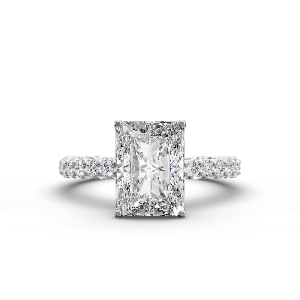 Radiant hidden halo engagement ring with three-row diamond band in studio lighting.