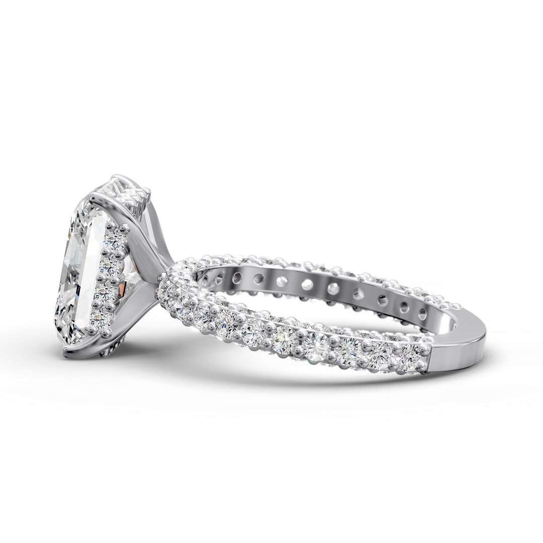 Radiant hidden halo engagement ring with three-row diamond band in studio lighting.