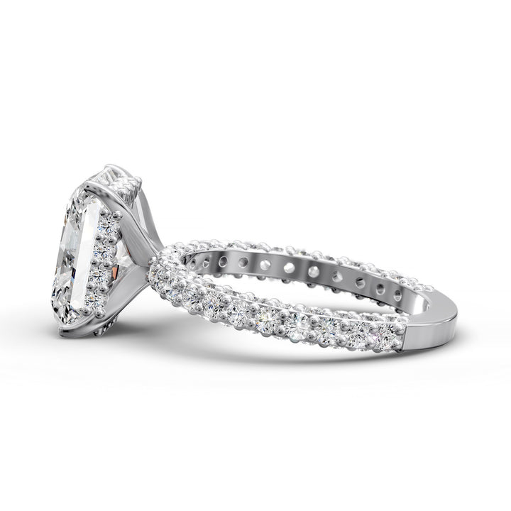 Radiant hidden halo engagement ring with three-row diamond band in studio lighting.