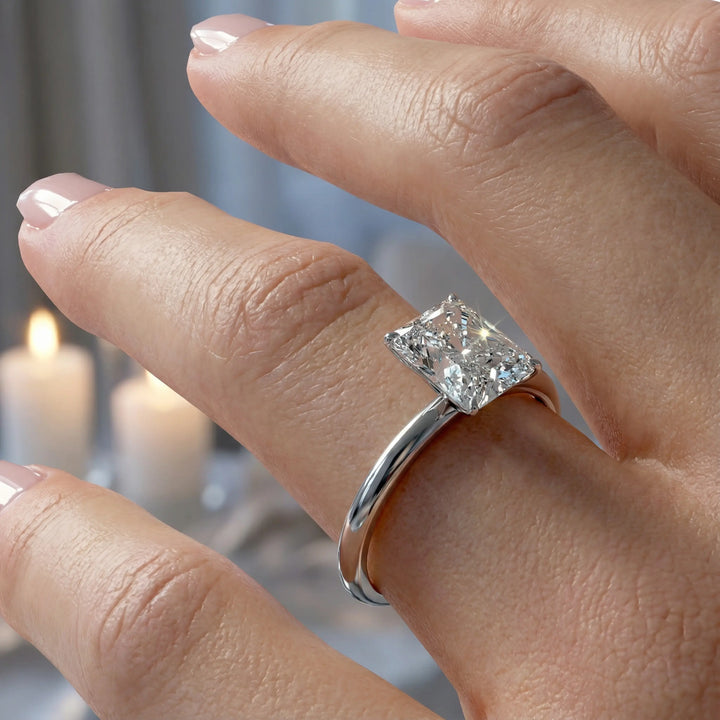 Radiant cut diamond solitaire engagement ring with a classic smooth band shown in display view.