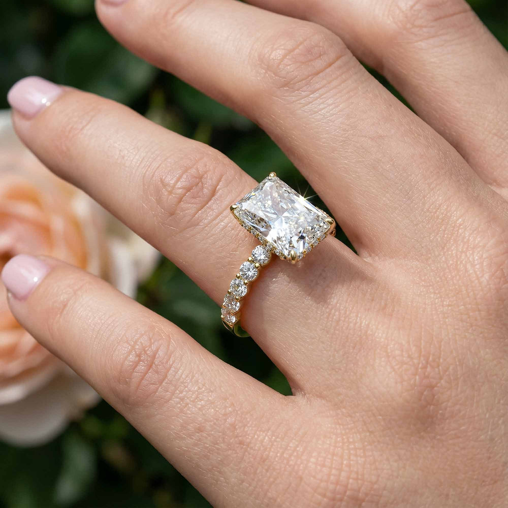 Radiant diamond hidden halo engagement ring with diamonds on band shown in display view.