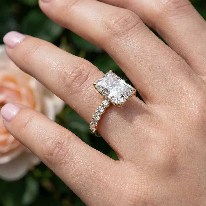 Radiant diamond hidden halo engagement ring with diamonds on band shown in display view.