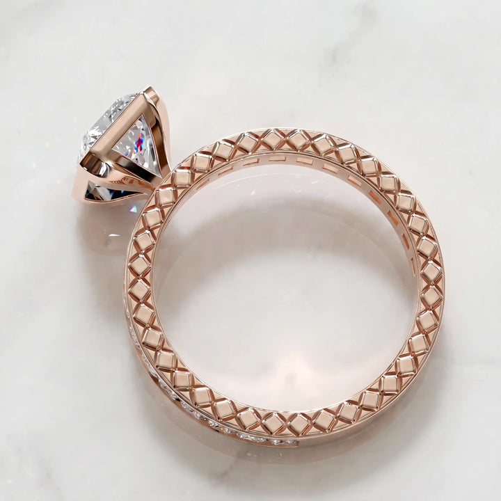 Radiant lab-grown diamond engagement ring with princess cut channel set band on marble display.