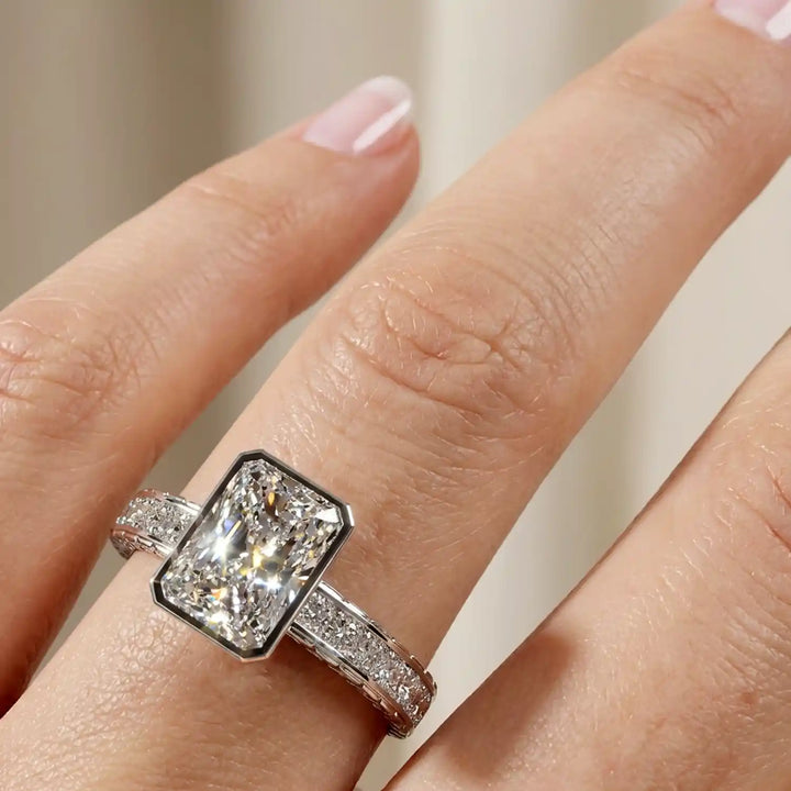 Radiant lab-grown diamond engagement ring with princess cut channel set band on hand.