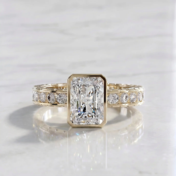 Radiant lab-grown diamond engagement ring with princess cut channel set band on marble display.