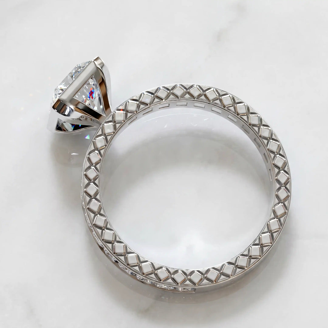 Radiant lab-grown diamond engagement ring with princess cut channel set band on marble display.