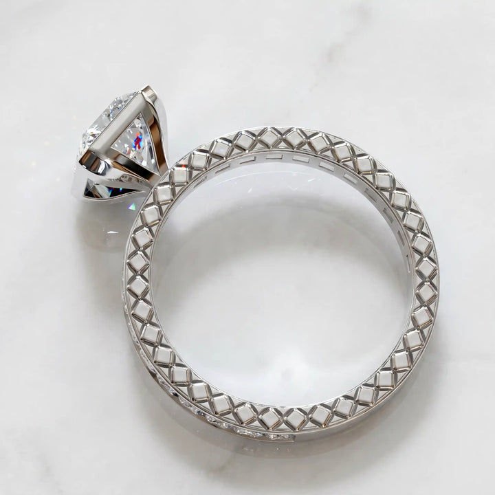 Radiant lab-grown diamond engagement ring with princess cut channel set band on marble display.