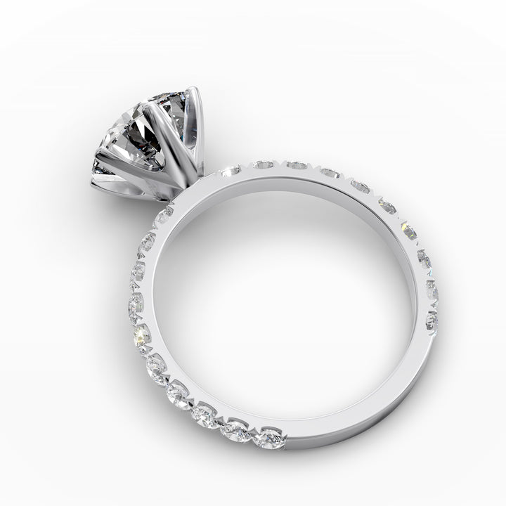 Round diamond pavé engagement ring with six-prong center stone on display.
