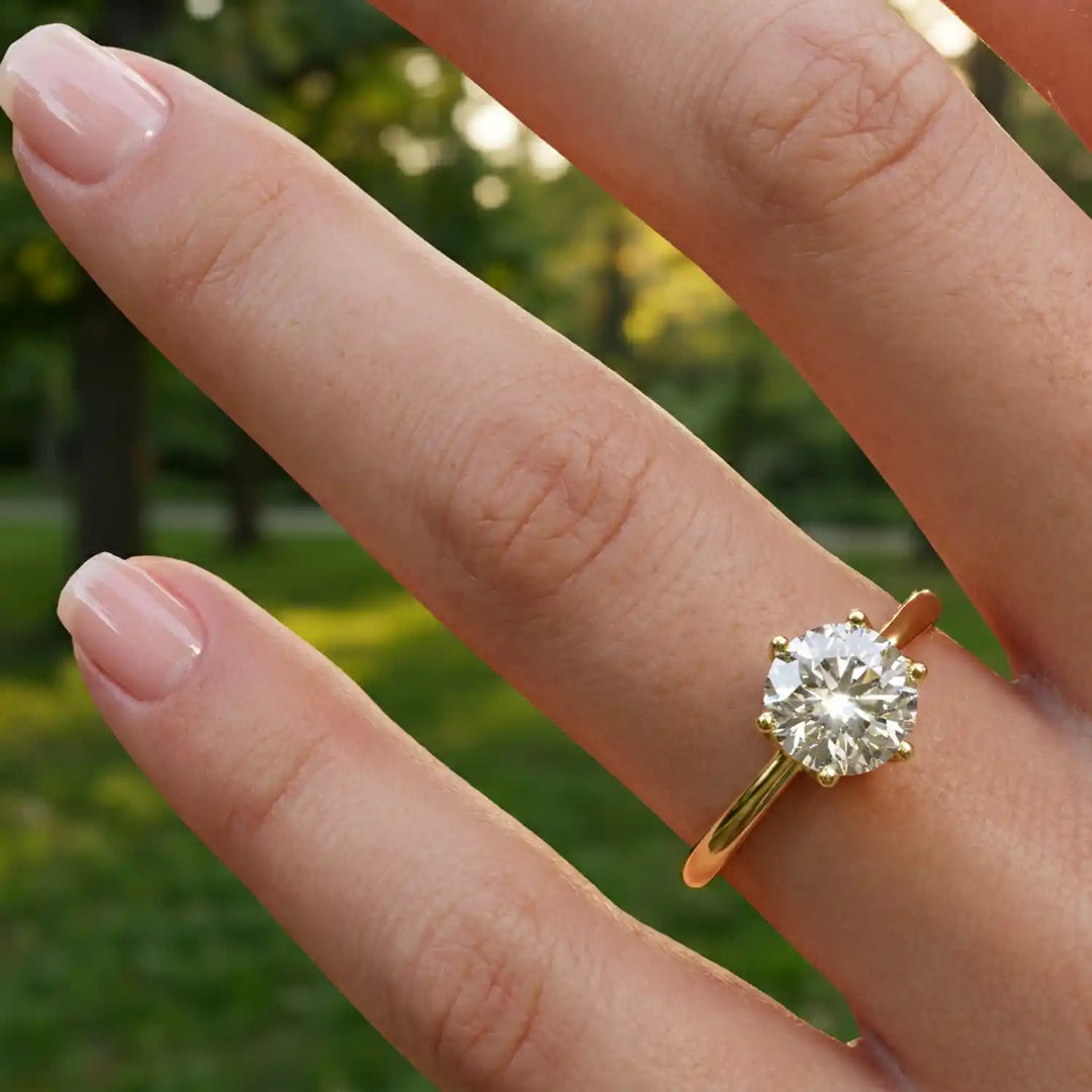 Round lab-grown diamond tulip prong engagement ring shown on hand.