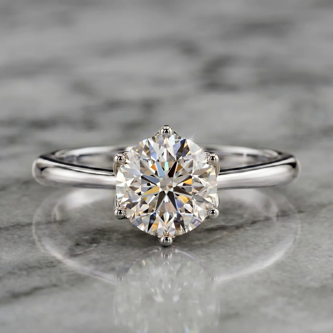 Round lab-grown diamond tulip prong engagement ring shown on marbel.