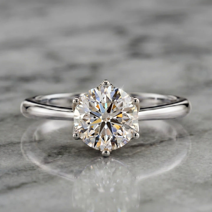 Round lab-grown diamond tulip prong engagement ring shown on marbel.