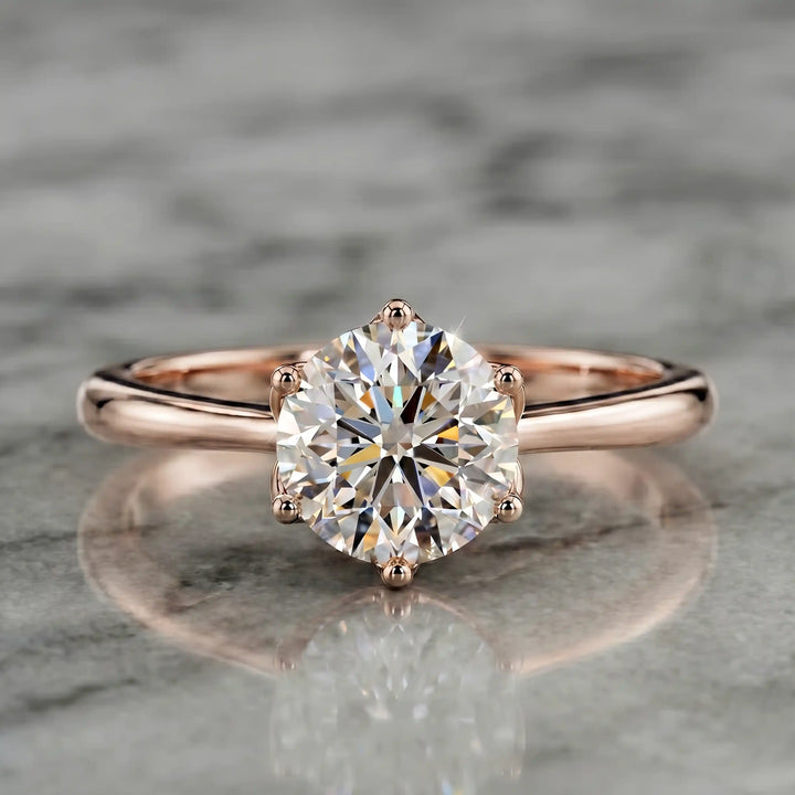 Round lab-grown diamond tulip prong engagement ring shown on marbel.