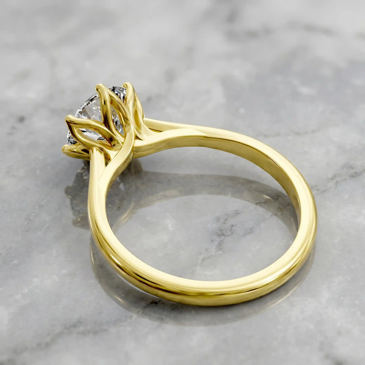 Round lab-grown diamond tulip prong engagement ring shown on marbel.