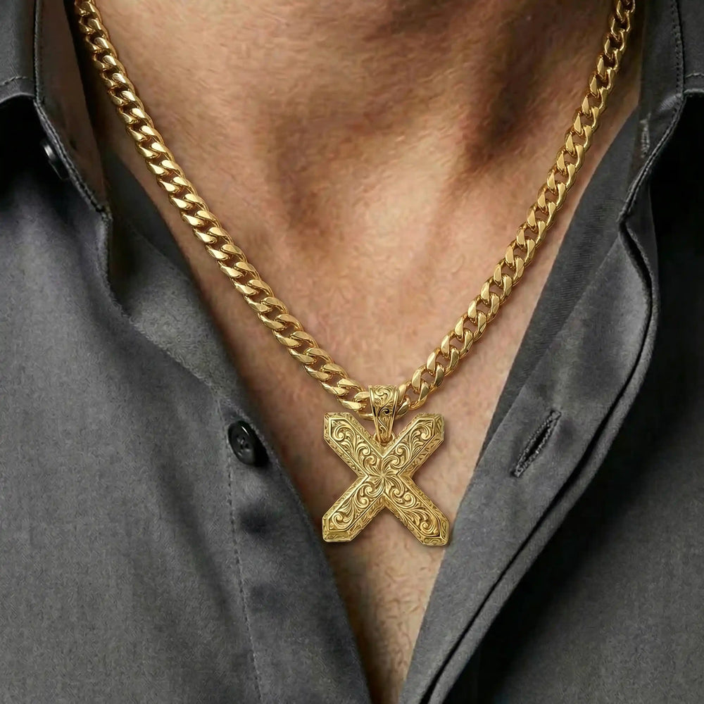 St. Andrew diagonal cross pendant with engraved ornamental design displayed on chest.
