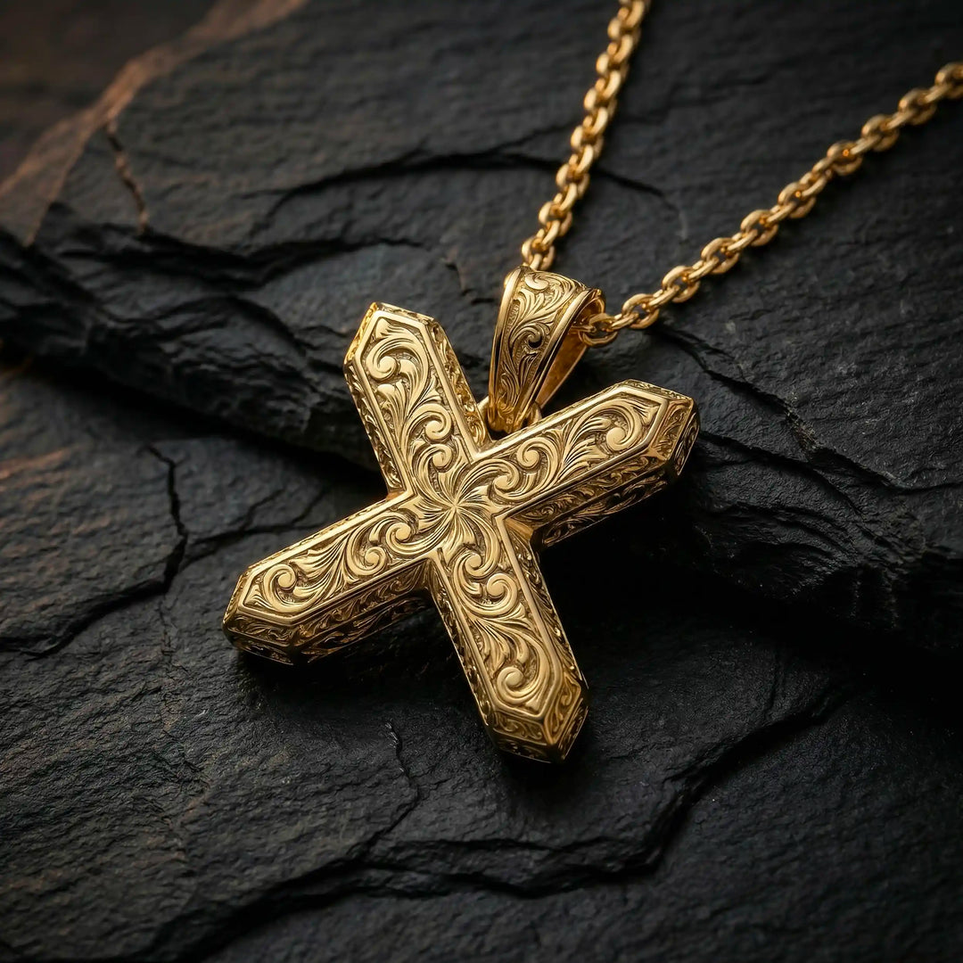 St. Andrew diagonal cross pendant with engraved ornamental design displayed on black stone.