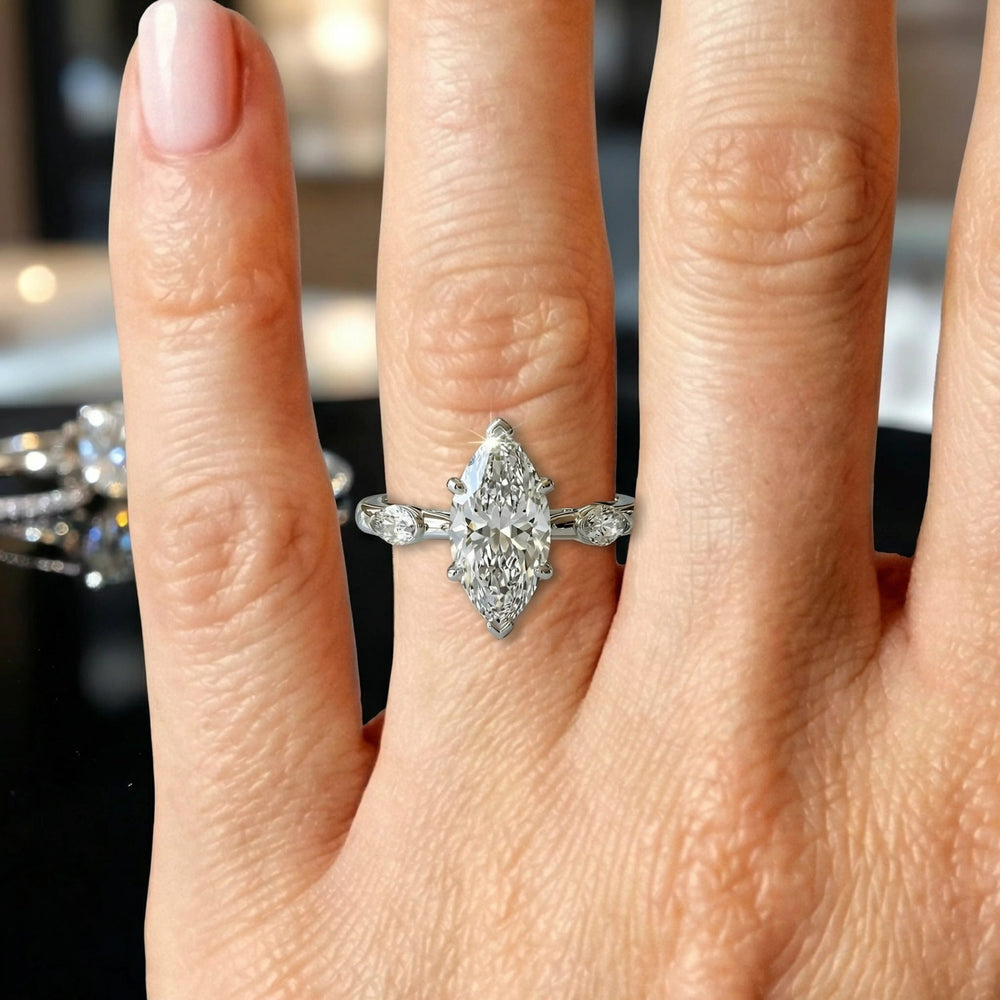 2.5 carat three stone marquise lab-grown diamond engagement ring displayed on marble surface.