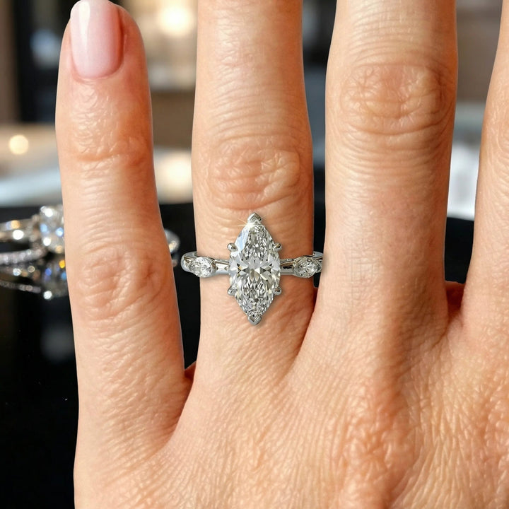 2.5 carat three stone marquise lab-grown diamond engagement ring displayed on marble surface.
