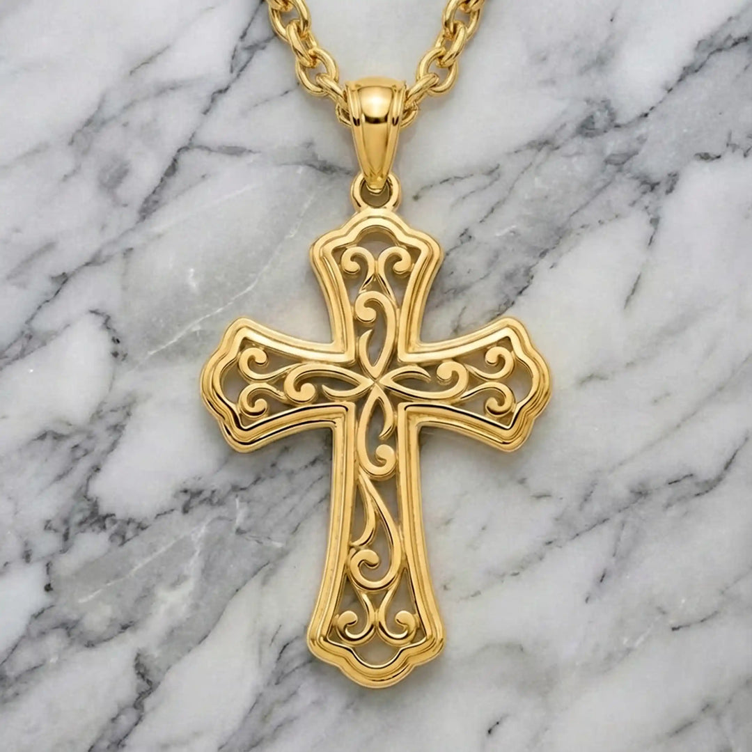 Ornate filigree Latin cross pendant necklace displayed on marble background.