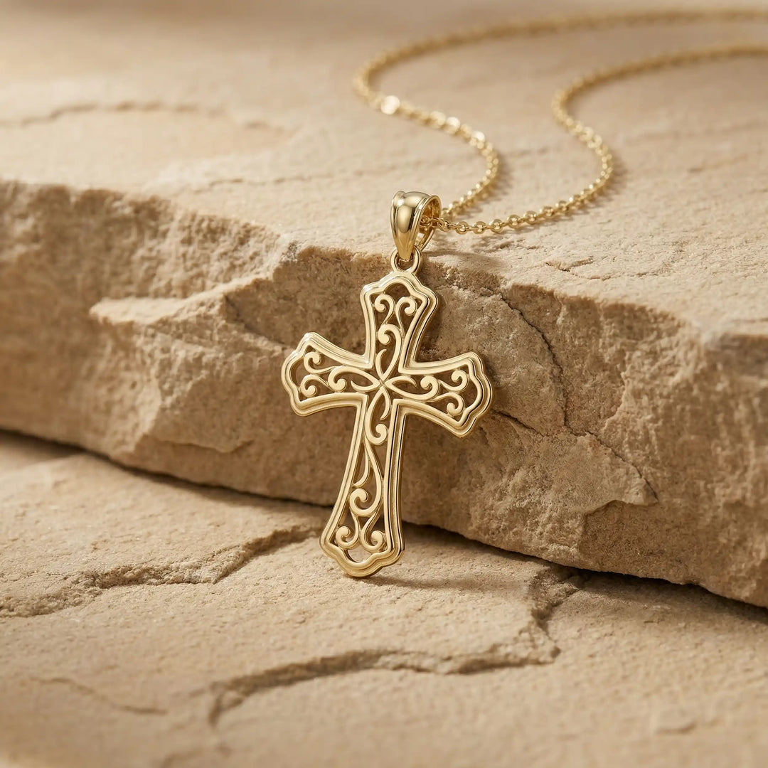 Ornate filigree Latin cross pendant necklace displayed on marble background.