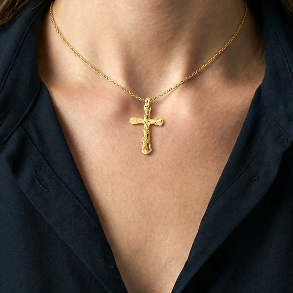 Vine cross pendant with engraved leaf detail displayed on female chest.