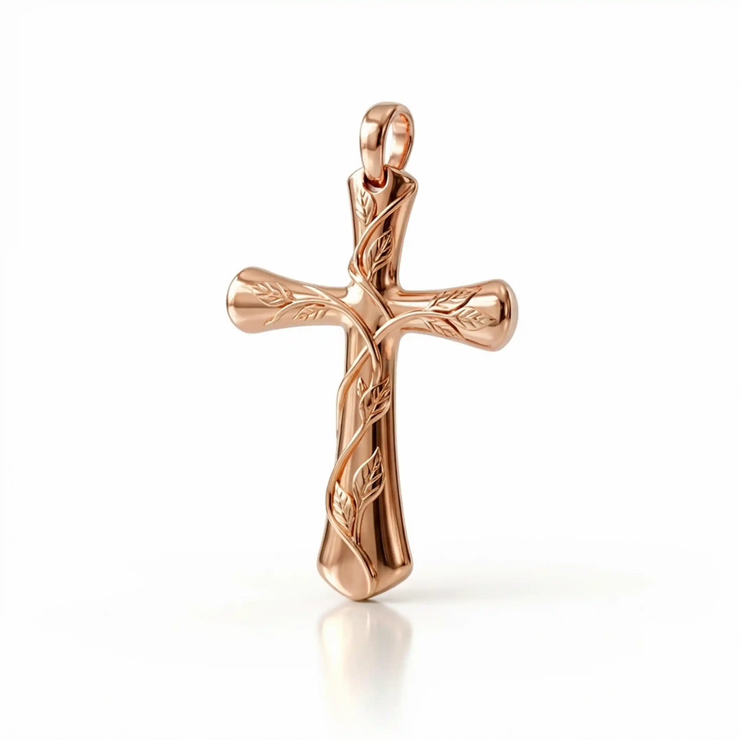 Vine cross pendant with engraved leaf detail displayed on white background.