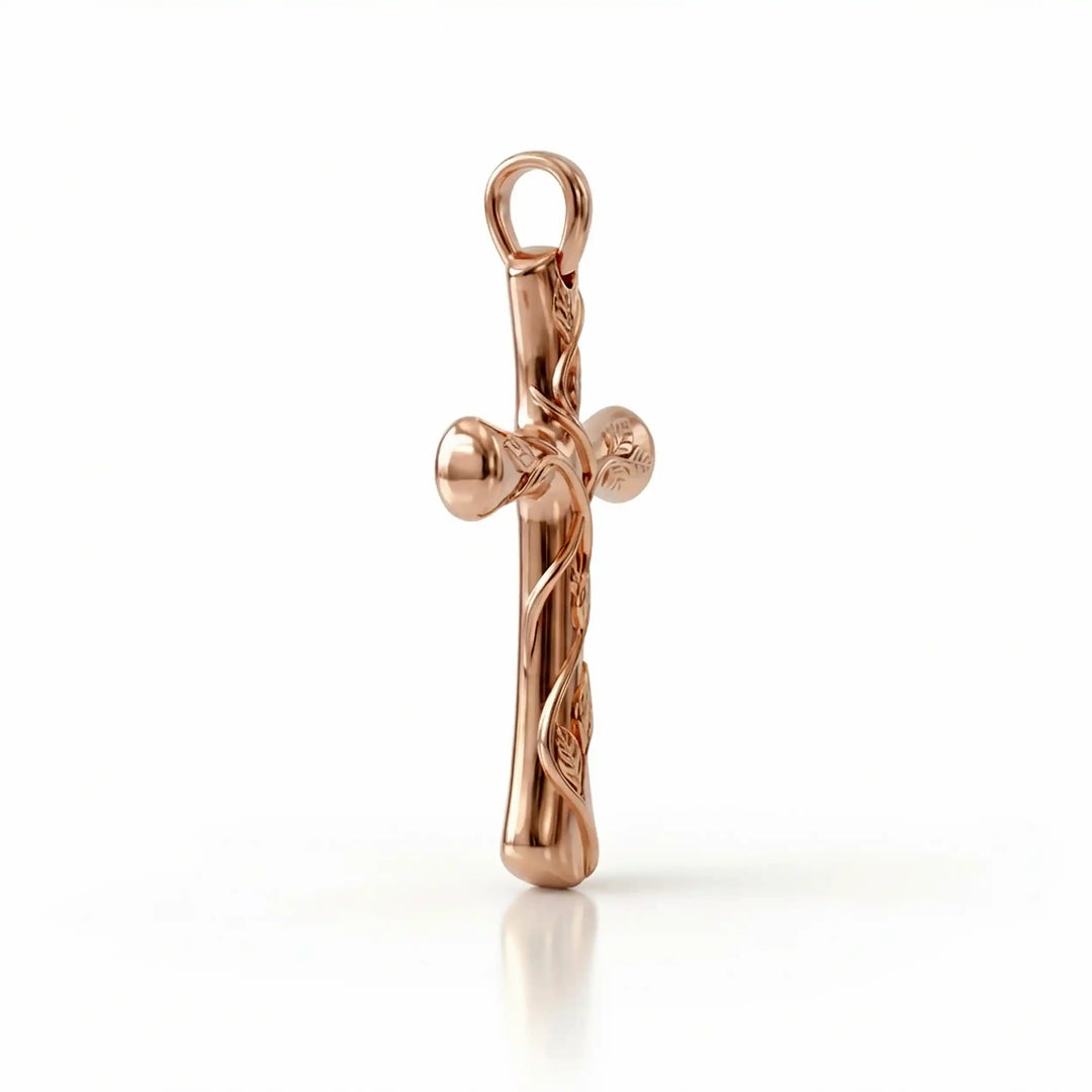 Vine cross pendant with engraved leaf detail displayed on white background.
