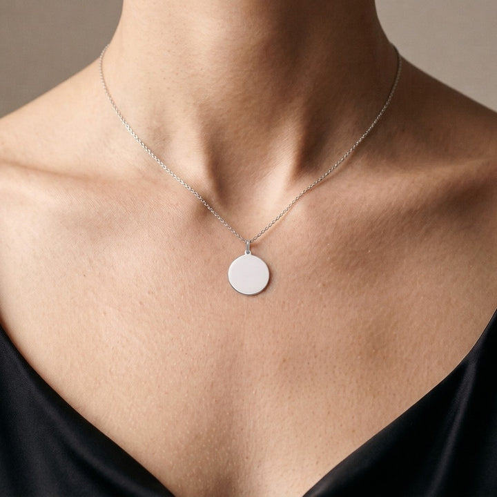 White gold polished round tag pendant, 18 mm diameter, 0.5 mm thick, worn by a woman on an 18 inch chain