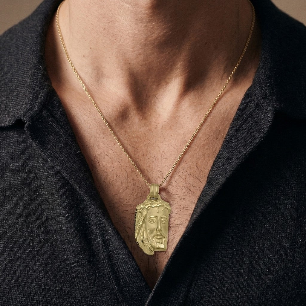 Yellow gold Jesus head pendant with a crown of thorns, flowing hair and a diamond-cut beard, 25.8 mm wide and 39.4 mm tall, worn by a man on a fine yellow gold chain
